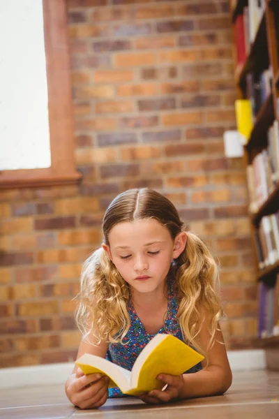 Mädchen liest Buch in Bibliothek — Stockfoto