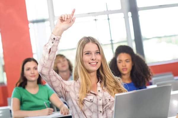 Estudante feminina levantando a mão na sala de aula — Fotografia de Stock