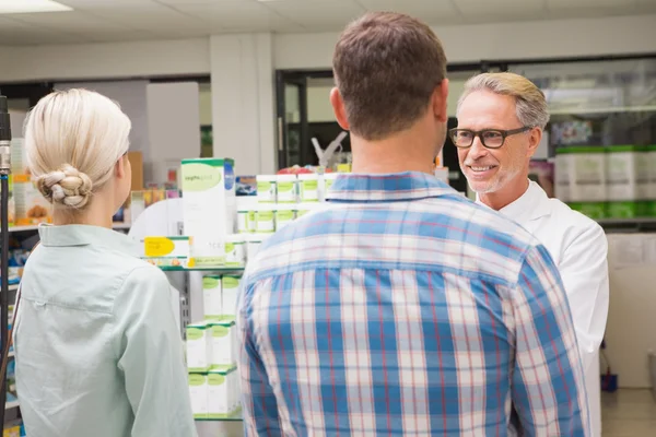 Pharmacist and customers talking about medication — Stock Photo, Image