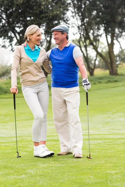 Couple smiling at each other on putting green — Stock Photo, Image