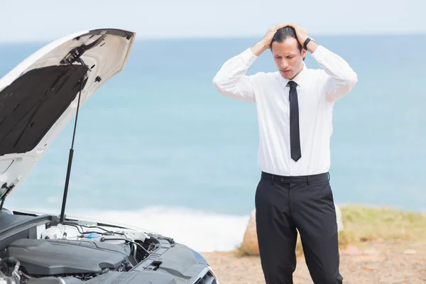 Stressed businessman looking at engine — Stock Photo, Image