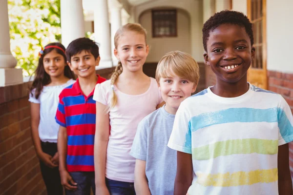 Усміхнені маленькі школярі в шкільному коридорі — стокове фото