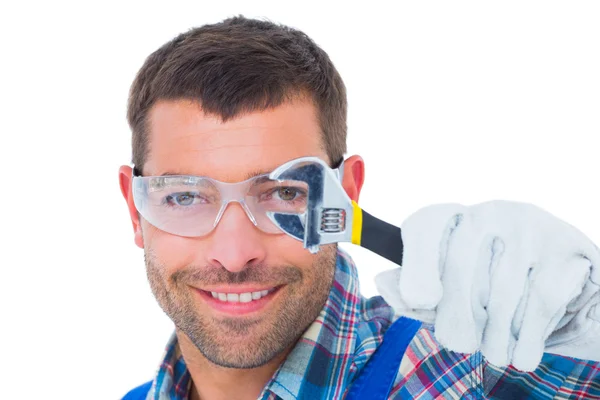 Happy repairman looking through wrench — Stock Photo, Image