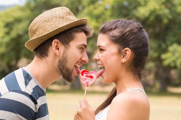 Cute couple sharing a lollipop — Stock Photo, Image