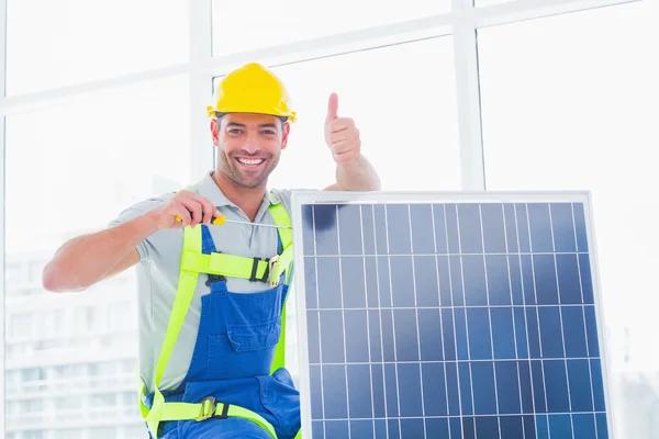 Männlicher Arbeiter schraubt Solarmodul fest — Stockfoto
