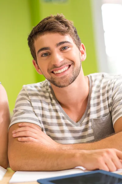 Retrato de estudante do sexo masculino feliz na biblioteca — Fotografia de Stock