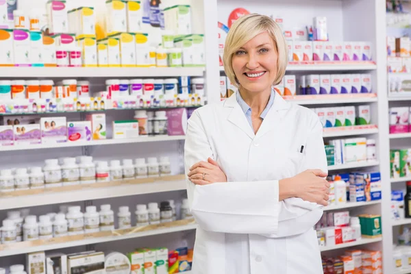 Pharmacien blonde avec les bras croisés souriant à la caméra — Photo