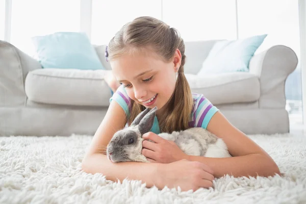 Ragazza che gioca con coniglio in camera — Foto Stock