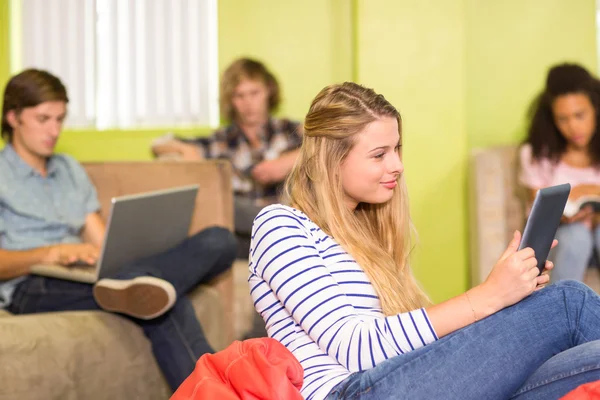 Dorywczo młoda kobieta za pomocą cyfrowego tabletu w biurze — Zdjęcie stockowe