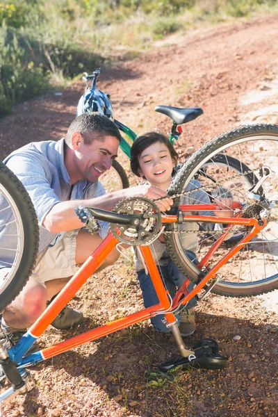 Отец и сын вместе ремонтируют велосипед. — стоковое фото