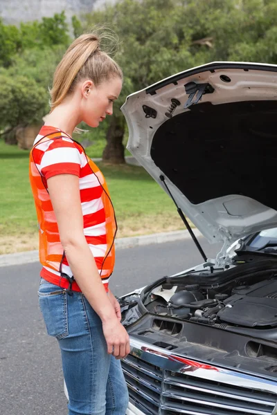 Волнуется молодая женщина рядом с ее сломанной машиной — стоковое фото