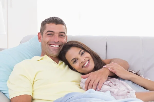 Szczęśliwa para leżąc na kanapie — Zdjęcie stockowe