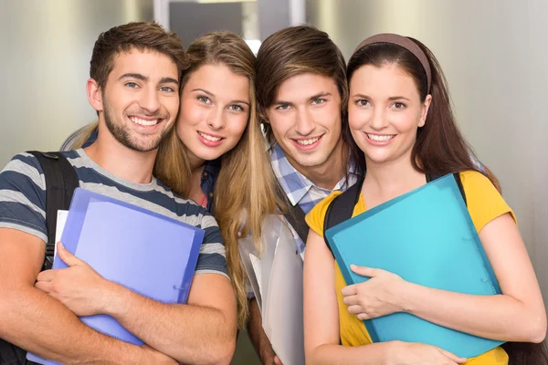 Glada studenter håller mappar på college korridor — Stockfoto