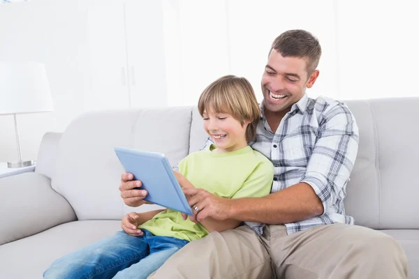 Pai e filho jogando jogo no tablet digital — Fotografia de Stock