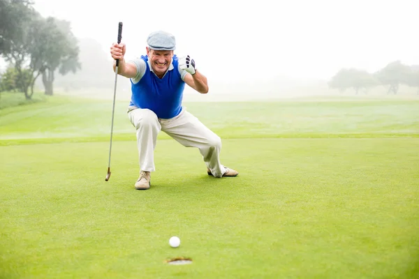 Happy golfer cheering on putting green Stock Photo