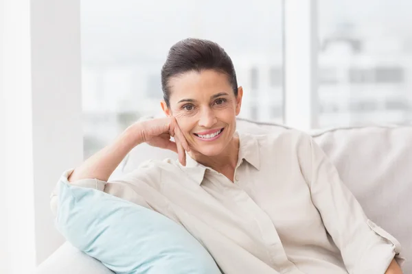 Happy woman relaxing on sofa Stock Picture