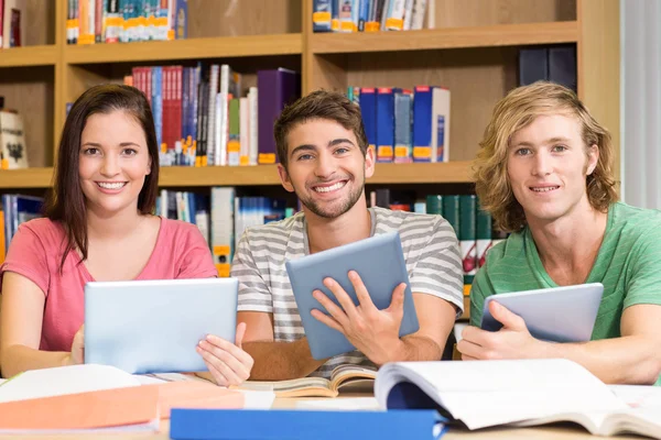 Studenti universitari che utilizzano tablet digitali in biblioteca — Foto Stock