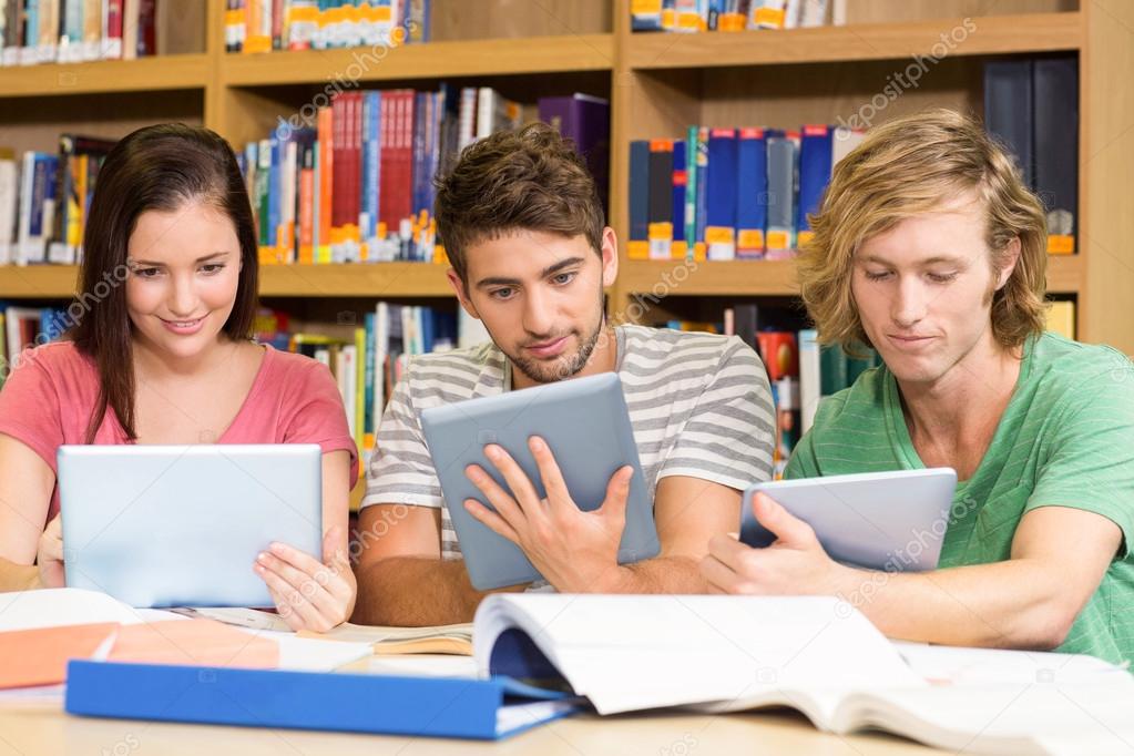 College students using digital tablets in library — Stock Photo