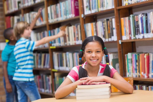 Schattig leerlingen op zoek naar boeken in bibliotheek — Stockfoto