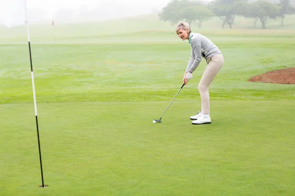 Леди гольфистка на зеленой дорожке — стоковое фото