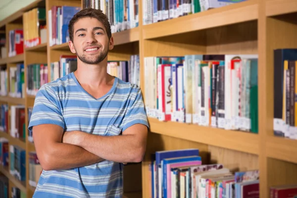 Student, uśmiecha się do kamery w bibliotece — Zdjęcie stockowe