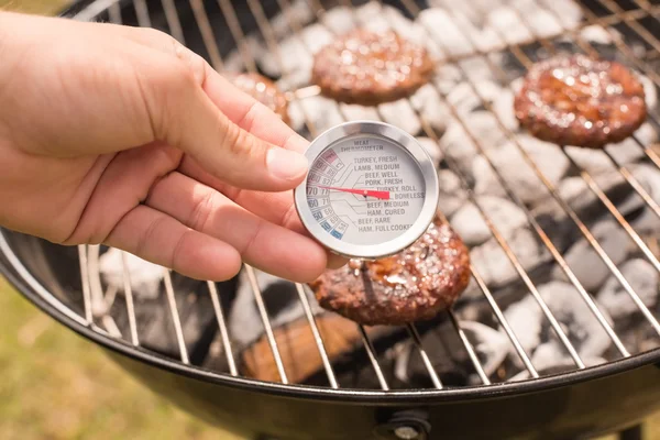 Człowiek za pomocą mięso termometr przy grillu — Zdjęcie stockowe