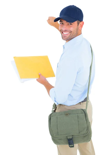 Smiling postman with letter knocking — Stock Photo, Image