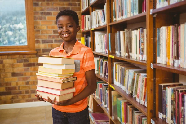 Aranyos fiú szállító könyvek, a könyvtár portréja — Stock Fotó