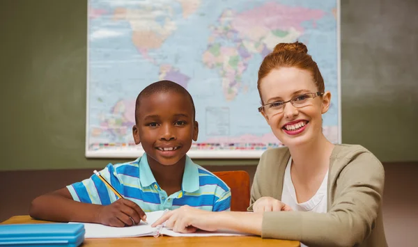 Teacher assisting little boy with homework in classroom — Stock Photo, Image