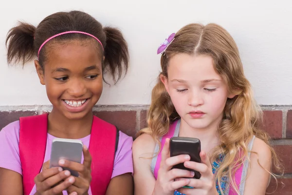 Pupilas lindas usando teléfono móvil —  Fotos de Stock