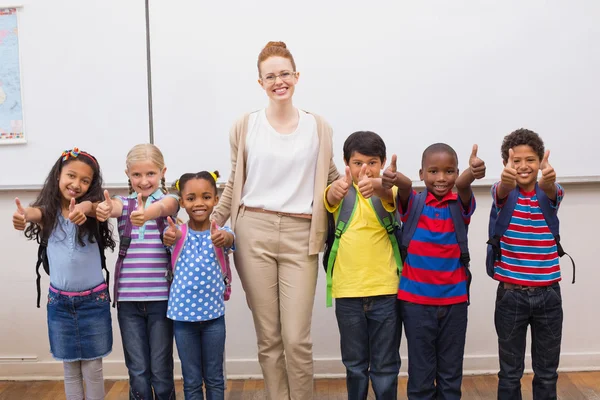 Enseignant et élèves souriant à la caméra en classe — Photo