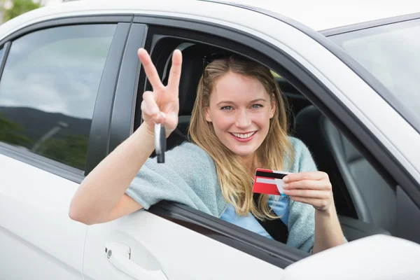 Mujer joven sonriendo y sosteniendo la tarjeta — Foto de Stock