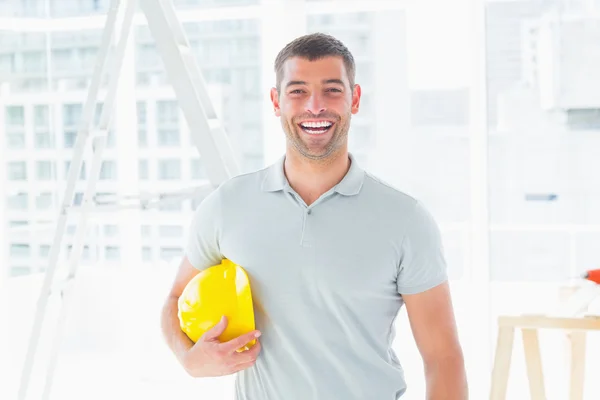 Alegre faz-tudo segurando hardhat — Fotografia de Stock