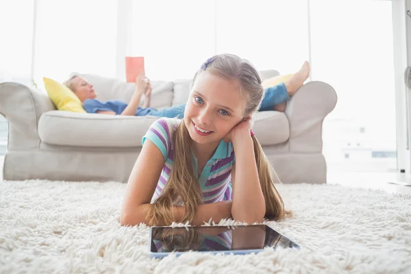 Menina usando tablet digital no tapete — Fotografia de Stock