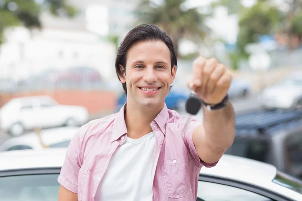 Young man smiling and holding key — Stock Photo, Image