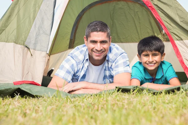 Father and son lying beside their tent — Stock Photo, Image