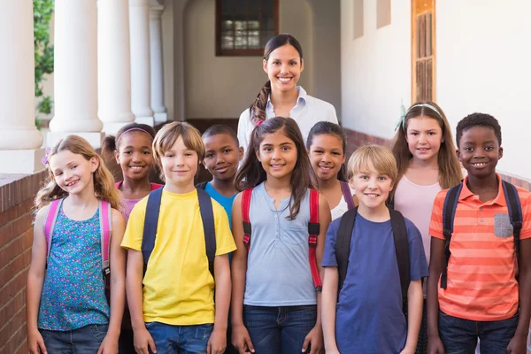 Cute pupils smiling at camera in the hall — Stock Photo, Image