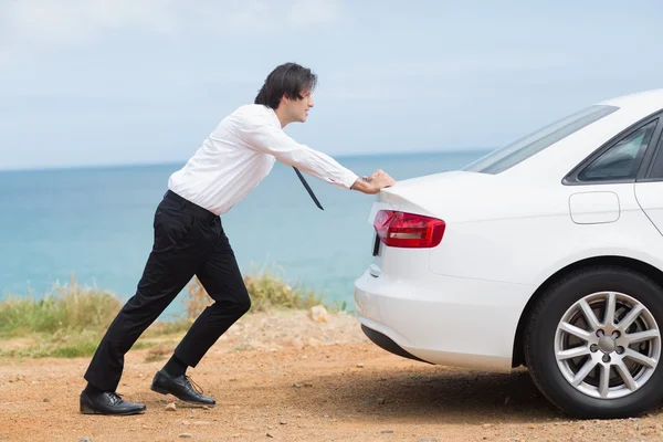 Geschäftsmann schiebt sein Auto — Stockfoto