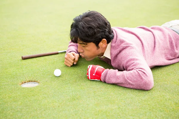 Golfer trying to flick ball into hole — Stock Photo, Image