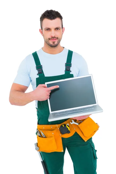 Sonriente trabajador de la construcción sosteniendo portátil — Foto de Stock