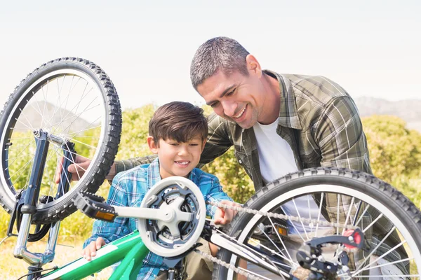 Father and son repairing bike — Stock Photo, Image