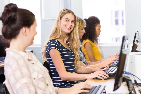 Studente sorridente alla macchina fotografica in classe di computer — Foto Stock