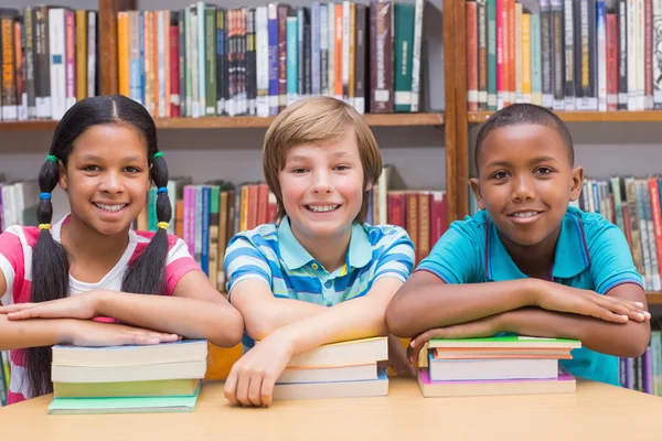 Cute pupils looking at camera in library — Stock Photo, Image