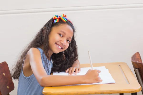 Élèves mignons écrivant au bureau en classe — Photo