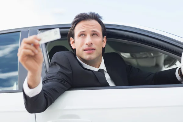 Бизнесмен показывает водительские права — стоковое фото