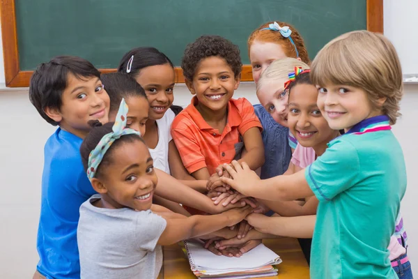 Mignons élèves souriant à la caméra dans la salle de classe — Photo
