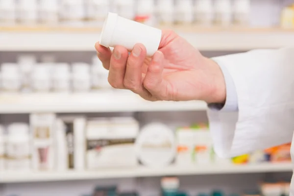 Mão do farmacêutico mostrando frasco de medicamento — Fotografia de Stock