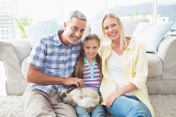 Parents and daughter with rabbit in room — Stock Photo, Image