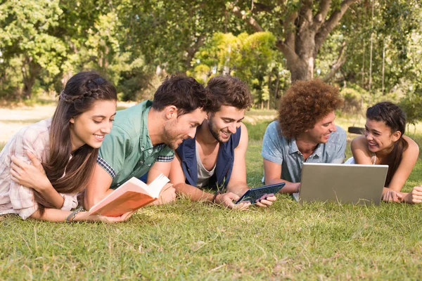 Amigos felizes no parque estudando — Fotografia de Stock