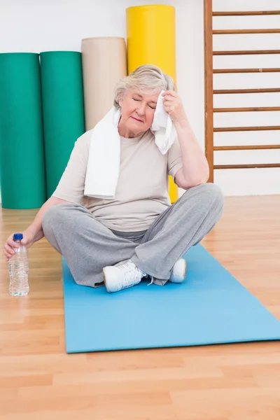 Cansado mulher idosa no tapete de exercício — Fotografia de Stock